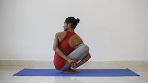 Yoga Asana gedrehte Hocke