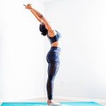 Yoga-Übung Tadasana vor weisser Wand